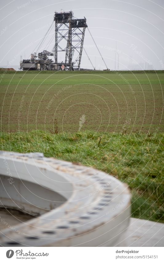 Sockel eines abgesägten Windrads, im Hintergrund ein Braunkohlebagger in Lützerath Nordrhein-Westfalen Energiewirtschaft Industrie Raubbau nachhaltig