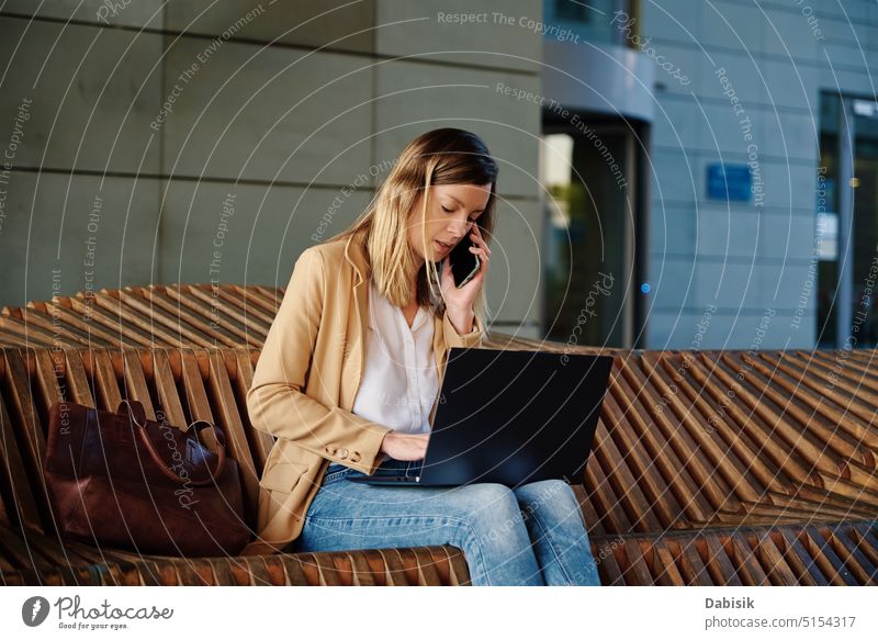 Frau sitzt mit einem Laptop auf einer Treppe im Freien bei Sonnenuntergang. Computer arbeiten freiberuflich online Bank abgelegen Gebäude e Lernen Netzwerk