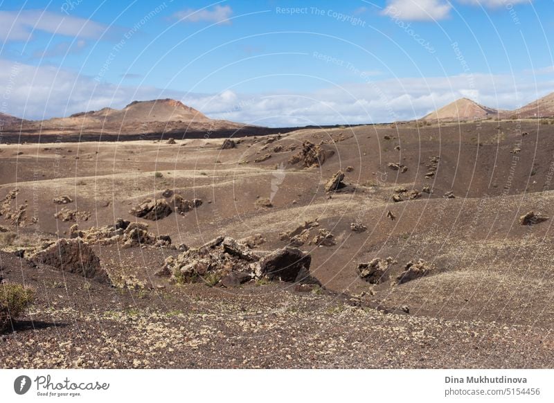 Vulkanlandschaft der Insel Lanzarote mit Bergen, Lavafeldern und blauem Himmel. Kanarische Inseln horizontalen Hintergrund. Braun-beige Farbpalette. natürlich