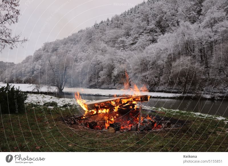 Kamin vor Winterlandschaft mit Schnee. Oberfläche des Feuers. Ausgewählter Fokus. abstrakt Hintergrund schwarz Brand lodernd Freudenfeuer Stiefel Baustein hell