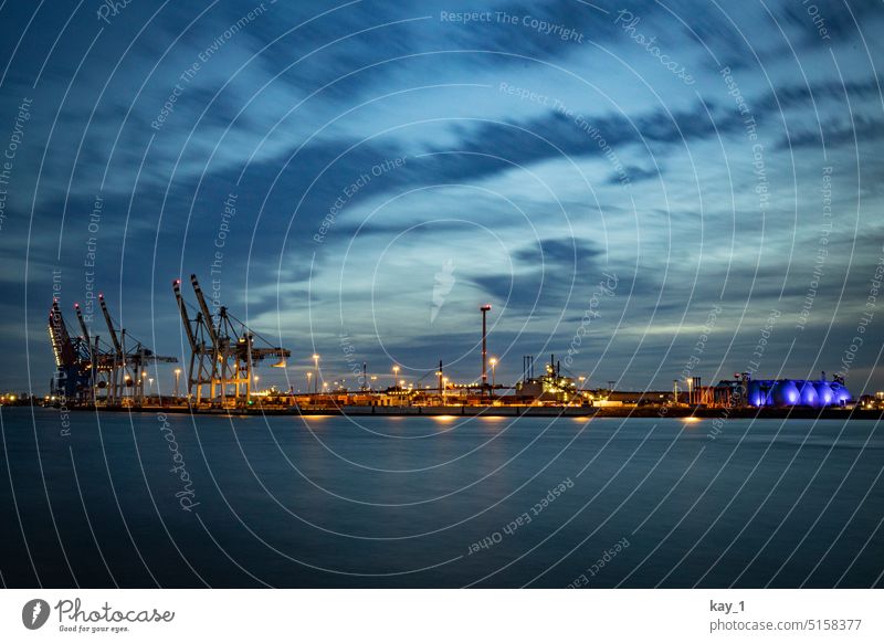 Hamburger Hafenanlage in der Abenddämmerung Elbe Fluss Sonnenuntergang Blaue Stunde Wolkenhimmel Küste Kräne Containerterminal Containerhafen Wasser Hafenstadt