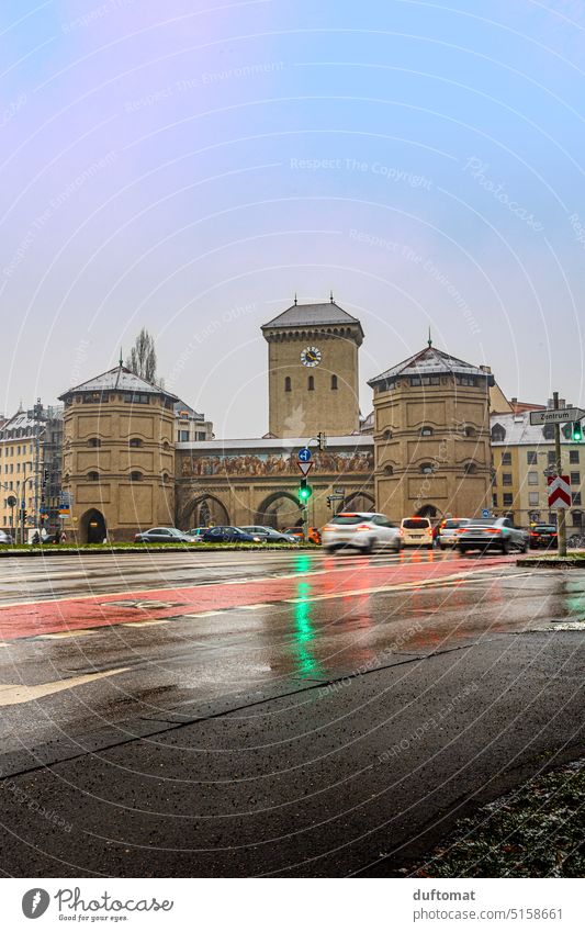 Regennasse Fahrbahn am Isartor in München Straße urban Weg Großstadt Asphalt Fußgänger Außenaufnahme Stadt bedeckt kalt nasskalt düster Abendlicht Bogen