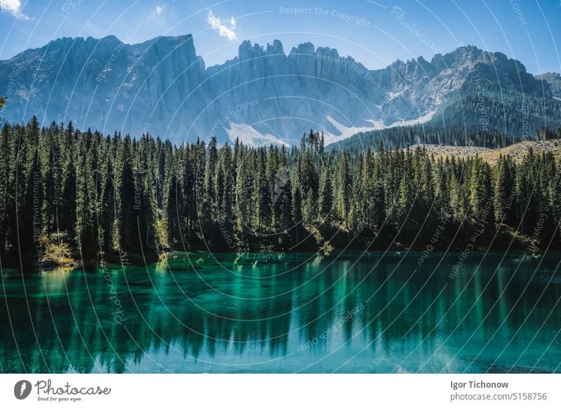 Wunderschöne Berglandschaft mit dem türkisfarbenen Wasser des Karersees und der Silhouette der Gipfel der Latemar-Gruppe im Hintergrund, Dolomiten, Italien See