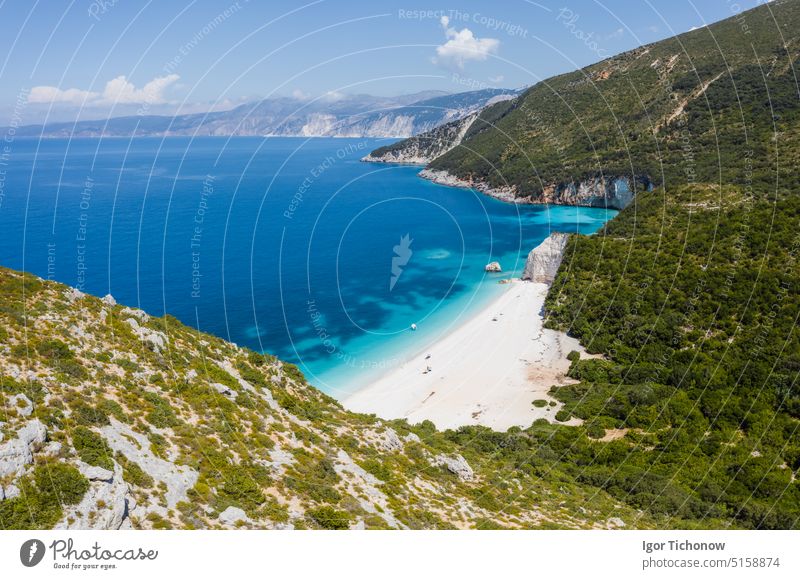 Atemberaubender Blick auf den Strand von Fteri mit weißem Segelboot in einer versteckten Bucht, Kefalonia, Griechenland. Umgeben von mediterraner Vegetation. Wanderweg. Erstaunliche Meereslandschaft