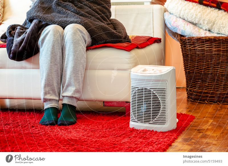 Heizperiode. Füße in Socken. Raum heizen mit Heizlüfter  Elektroheizung zu Hause. Saison Erwachsener Gerät Kleidung Erkältung und Grippe kalte Temperatur Farbe