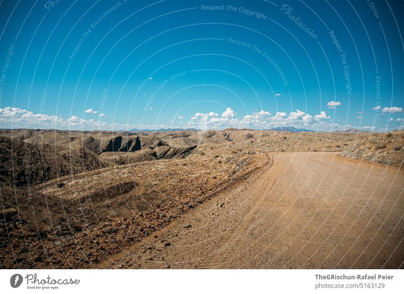 Kies-Strasse mit Bergen im Hintergrund Namibia Straße gravel road fahren entdecken Ferien & Urlaub & Reisen Farbfoto Außenaufnahme Menschenleer Freiheit Tag