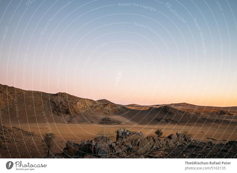 Steinwüste vor Bergen in Abendstimmung Namibia Steine Berge u. Gebirge reisen Landschaft Natur Felsen Ferien & Urlaub & Reisen Afrika Außenaufnahme Ferne