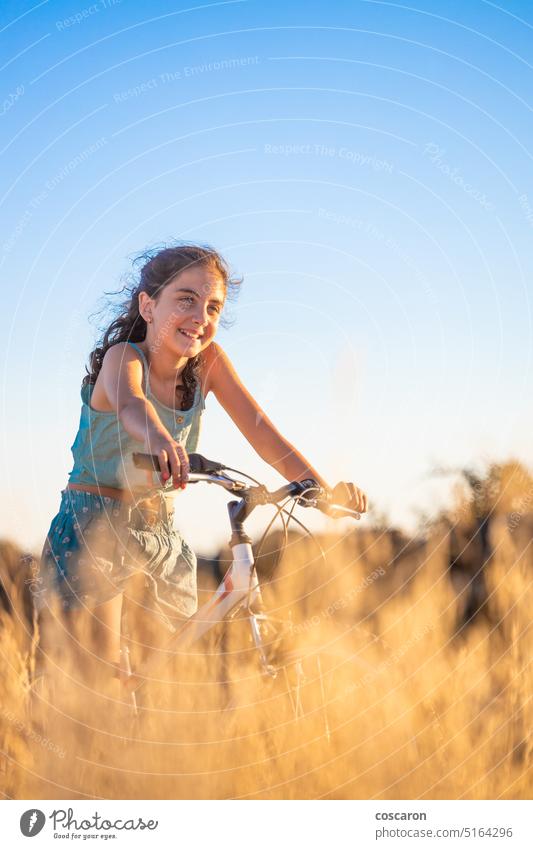 Nettes Mädchen mit ihrem Fahrrad im Sommer. aktiv Schönheit Radfahren Blauer Himmel Kaukasier Kind Landschaft Zyklus Fahrradfahren Radfahrer trocknen Frau Feld