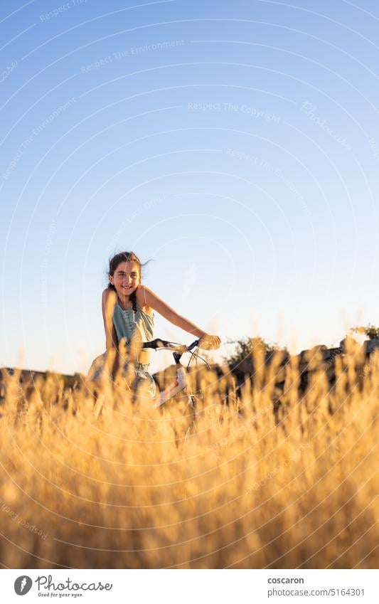 Nettes Mädchen mit ihrem Fahrrad im Sommer. aktiv Schönheit Radfahren Blauer Himmel Kaukasier Kind Landschaft Zyklus Fahrradfahren Radfahrer trocknen Frau Feld