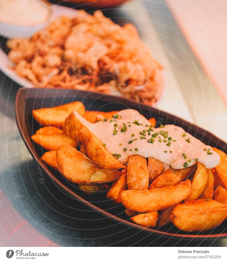 Bratkartoffeln mit Sauerrahmsauce auf einem Teller in einem Restaurant Amuse-Gueule Hintergrund gebacken brava Bravas Mut mutige Kartoffeln Nahaufnahme