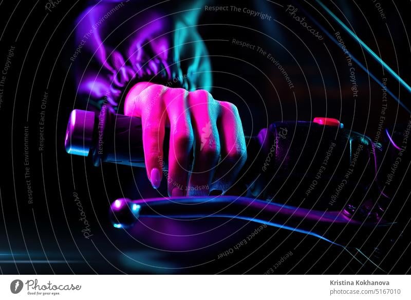Fahrer weibliche Hand dreht Beschleunigungsmesser Hebel bei Nacht Stadt. Neonlicht. Aktion aktiv Abenteuer schön Fahrrad Biker Bremse britannien caferacer