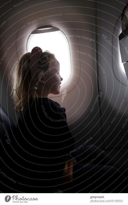 Positives Mädchen im Flugzeug in der Nähe des Fensters Kind Passagier reisen Fluggerät Ausflug Sitz Ebene Lächeln Verkehr Reise Glück Urlaub sitzen Kindheit