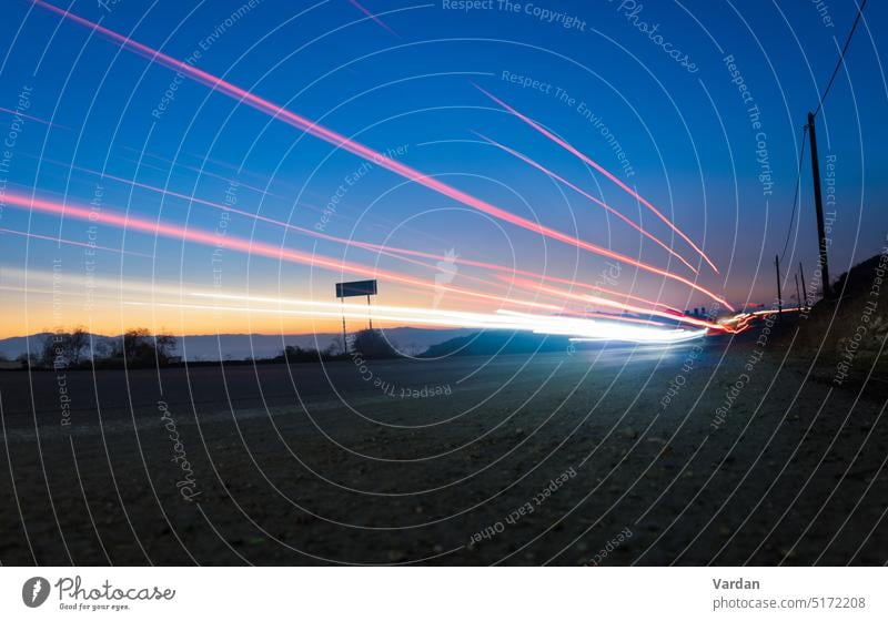 Leichte Spuren von vorbeifahrenden Autos bei Sonnenuntergang. Lange Belichtungszeit, Bewegungsunschärfe-Effekt. abstrakt Armenien Strahl unten hell PKW Farbe