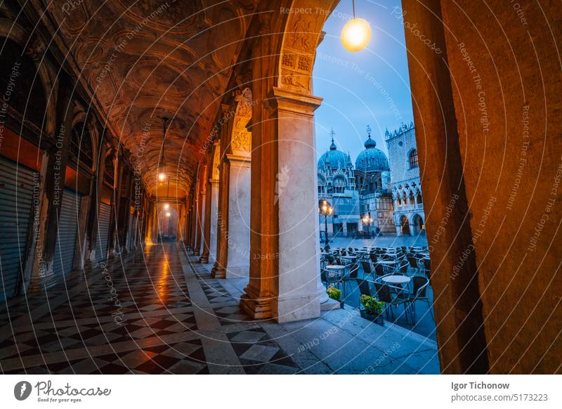 Abendlicher Blick auf die Basilica di San Marco und den Campanile durch den Straßenbogengang auf San Marco in Venedig, Italien. Stadtbild von Venedig in der Morgendämmerung, blaue Stunde