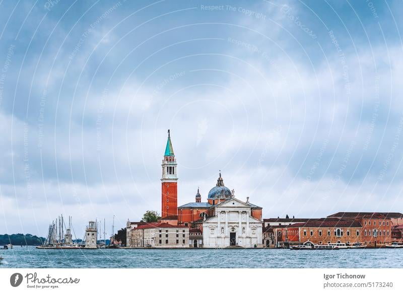 Venice, Italy. Chiesa di San Giorgio Maggiore or San Giorgio Maggiore island against blue sky with moody rainy clouds. tower church italy venice europe lagoon