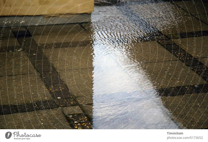 Auf Regen folgt Sonnenschein Wasser Regenwasser Wasseroberfläche kräuseln Spiegelung Gebäude Hauswand Licht Schatten Vorplatz Bodenbelag Steinplatten