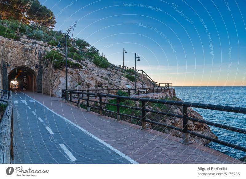 Tunnel des Cantal, zwischen Rincon de la Victoria und Cala del Moral, Málaga, Promenade, die durch Tunnel und Klippen mit Blick auf das Mittelmeer führt, bei Sonnenaufgang.