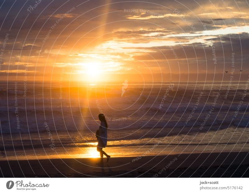 Spaziergang mit Sonnenstrahlen bei Sonnenaufgang am Strand Frau Meer Romantik Ferien & Urlaub & Reisen Erholung Sommerurlaub Sonnenlicht Natur Freiheit