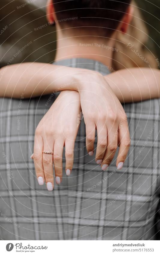 junge frau kreuzt ihre hände auf dem hals des mannes. brauthand mit goldring und maniküre. rückansicht Ring schön Braut Paar Hochzeit niedlich Tag Mädchen