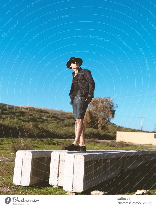 Stylish Mann in der Natur gegen den klaren blauen Himmel Stil gestylt Styler stylisch stylen Stylist Stile stilistisch schicke Kleidung Lebensstil Mode modisch