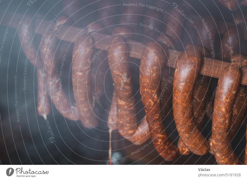 Heimbraten von Qualitätswürsten aus hausgemachten Killerwürsten, die gerade in einem Holzschuppen bei einer präzisen Temperatur geräuchert werden erwärmen