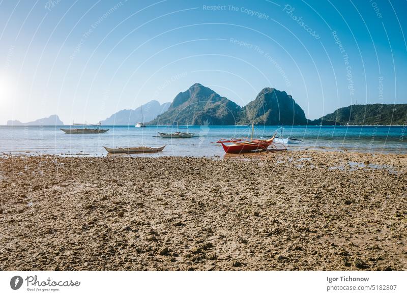 El Nido, Palawan, Philippinen. Einheimische Fischerboote bei Ebbe am Las Cabanas Beach mit beeindruckenden Bergen im Hintergrund reisen Strand Boot palawan blau