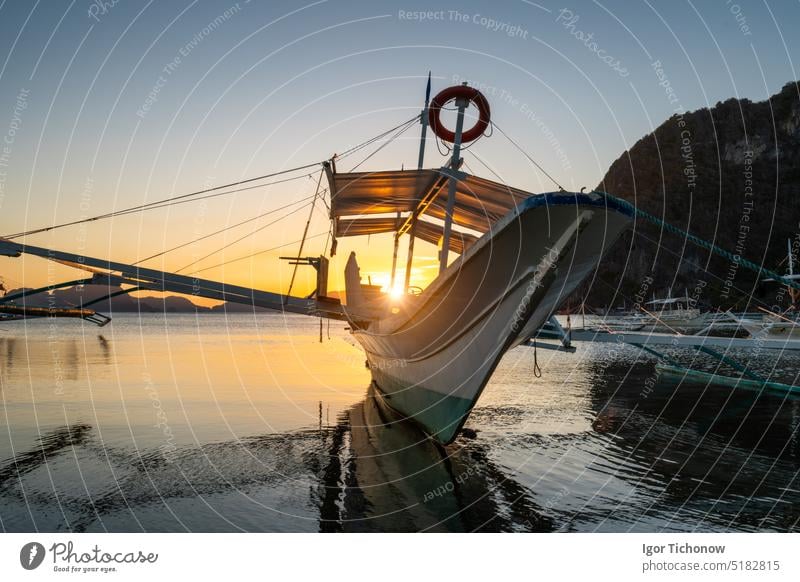 Tropische Hafenbucht am Abend. Goldene Stunde in der Lagune auf den Philippinen, Palawan, El Nido. Sonnenuntergang am Strand. Ruhiger malerischer Sonnenuntergang über Bergen Inseln am Horizont