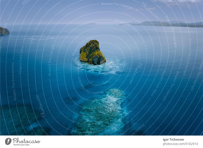 Drohnenaufnahme einer wunderschönen, abgelegenen, surrealen Felseninsel, umgeben von azurblauem Wasser. Der Bacuit-Archipel ist einer der besten Orte zum Tauchen. El Nido, Palawan