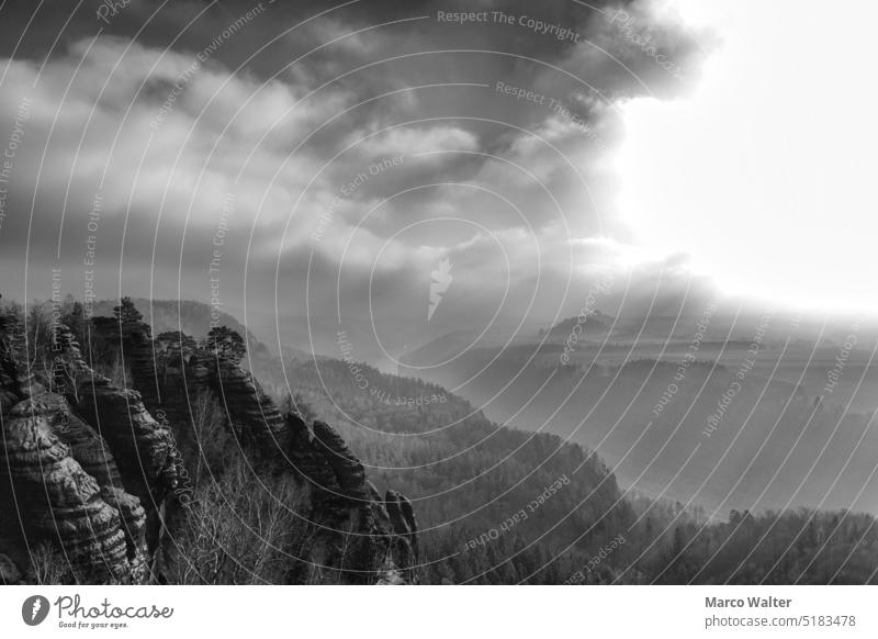 Über der Sächsischen Schweiz scheint die Sonne über den Wäldern und auf die Felsen und die Elbe fließt hindurch in Monochrom Sächsische Schweiz schwarz weiß