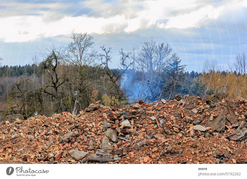 rauchende Ruine eines alten abgerissenen Bauernhauses In Gaishaus bei Ravensburg in Baden Würtemberg an einem bewölkten Tag im Winter Gebäude wolkig