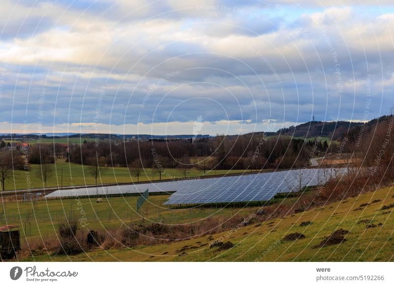 Solarpark in ländlicher Umgebung vor einer Bahnlinie in Gaishaus bei Ravensburg in Baden Würtemberg an einem bewölkten Tag im Winter CO²-Neutralität