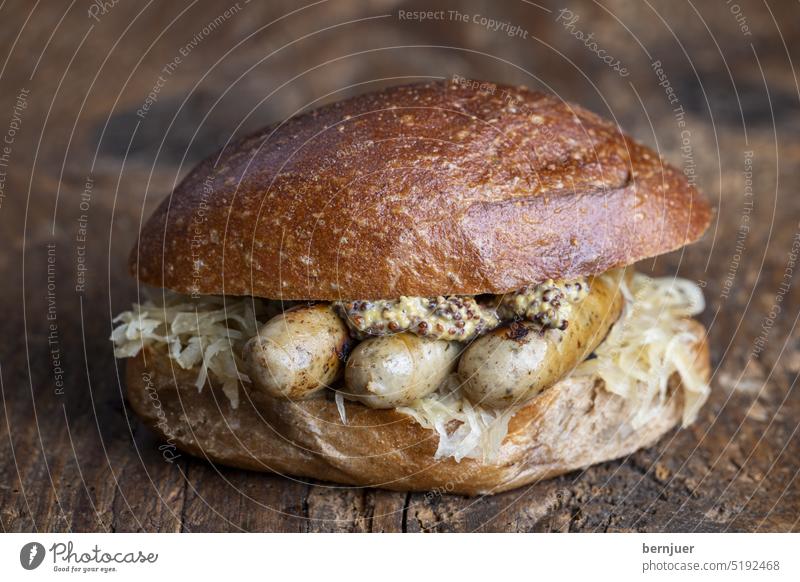 Gegrillte Nürnberger Würstchen im Brötchen Bratwurst Franken Wurst Jause rustikal Holz Sauerkraut Roggen Senf frisch gebraten Fleisch Bayern Mahlzeit Brot