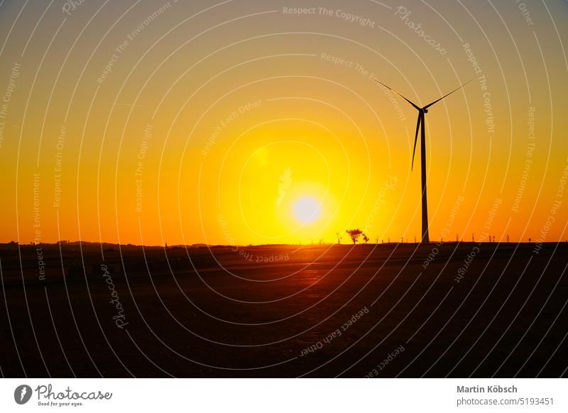 Onshore-Windkraftanlage auf einer Wiese bei Sonnenuntergang. Erneuerbare Energie. Sauberer Strom an Land saubere Energie zweite Änderung Netzbetreiber