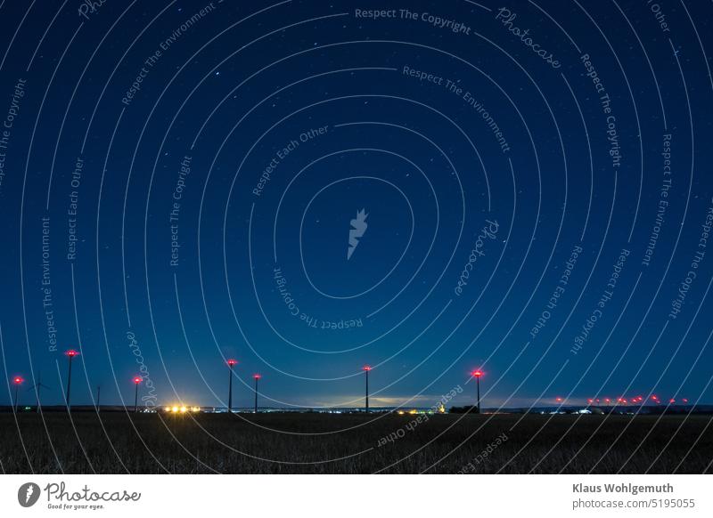 Nacht über der Kleinstadt Friedland in Mecklenburg- Vorpommern, viele Windräder sind in der Umgebung zu sehen, Sterne leuchten am Himmel Nachthimmel