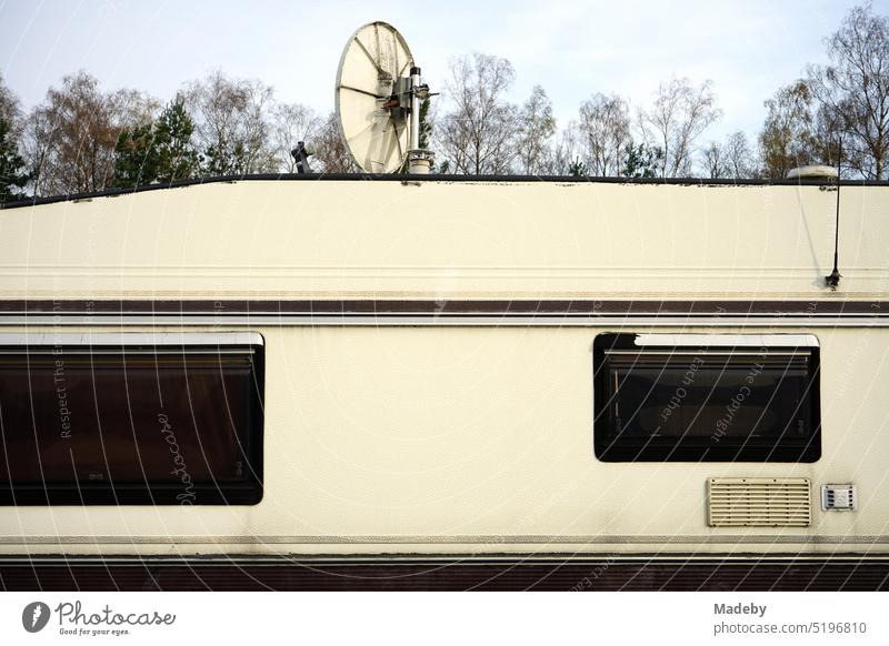 Wohnwagen in Beige und Naturfarben für Camping und Vanlife mit Satellitenschüssel für den Fernsehempfang auf dem Campingplatz am Segelflugplatz in Oerlinghausen bei Bielefeld am Hermannsweg im Teutoburger Wald in Ostwestfalen-Lippe