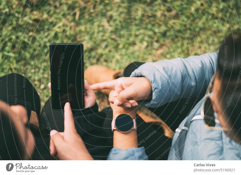 Ausgeschnittene Hände einer Frau mit einer intelligenten Uhr, die auf ein Smartphone, ein Technologiekonzept, soziale Netzwerke usw. hinweisen. Süchtige