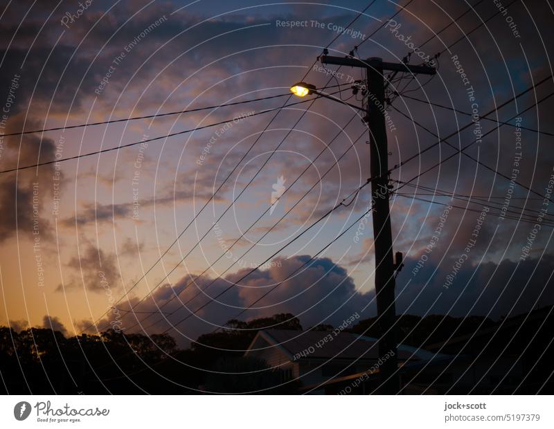 erleuchtet werden am Abend bevor die Nacht kommt Abendstimmung Dämmerung Sonnenuntergang Himmel Wolken Blaue Stunde Strommast Lichterscheinung Silhouette