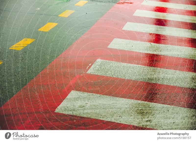 Zebrastreifen-Schild auf einer nassen Straße. Asphaltierte Straße mit Zebrastreifen. Regen Minimalismus Anleitung Transport Ausflugsziel Konzept Zeigen