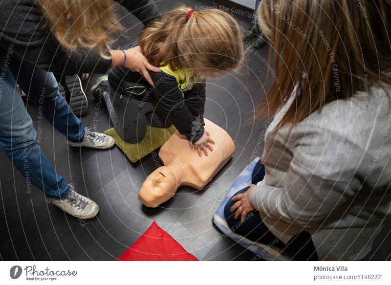 Drei Personen üben Erste Hilfe und Wiederbelebung mit einer Wiederbelebungspuppe Dummy Kurs Widerbelebung cpr Dummy medizinische Verfahren Medizin Krankheit