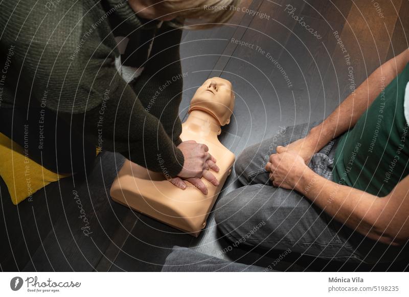 Zwei Personen üben Erste Hilfe und Wiederbelebung mit einer Wiederbelebungspuppe Dummy Kurs Widerbelebung cpr Dummy medizinische Verfahren Medizin Krankheit