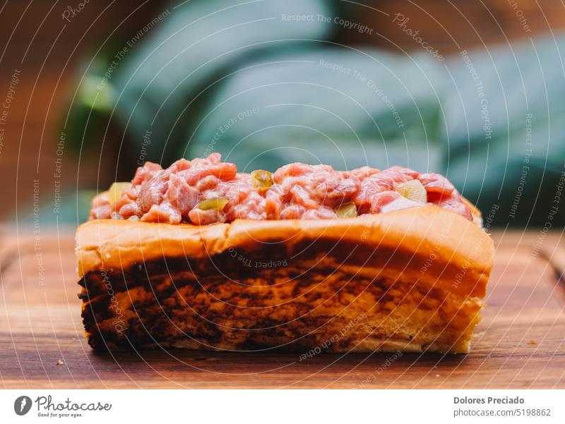 Premium-Rindertartar im Muffinbrot Amuse-Gueule Hintergrund Rindfleisch schwarz Holzplatte Brot gehackt farbenfroh Essen zubereiten Küche lecker Dessert