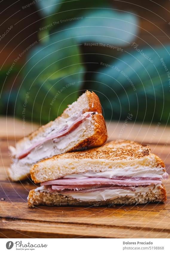 Frühstückssandwich mit Speck, Käse und Tomatensauce auf Holzbrett Amerikaner Amuse-Gueule Hintergrund Brot Cheddar Kirsche Nahaufnahme Club Essen zubereiten