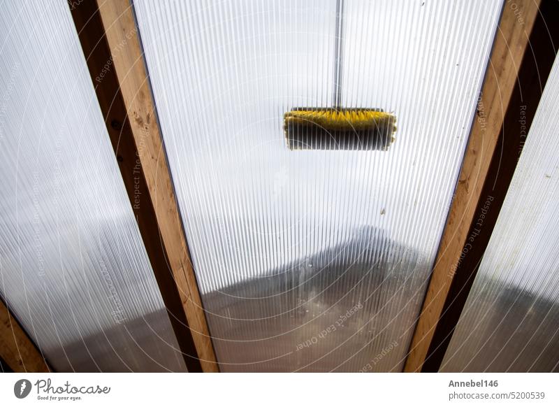 Waschen der Terrassenüberdachung aus Aluminium. Entfernen der schmutzigen Algen mit Bürste, Seife und Wasser aus der Nähe im Garten von der Terrasse eines Hauses