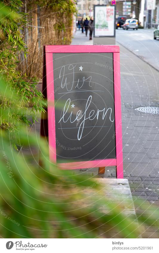 Aufstelltafel auf dem Gehweg vor einem Geschäft mit der Aufschrift " Wir liefern " Lieferservice Ladengeschäft gastronomie bringservice Stadt Bürgersteig urban