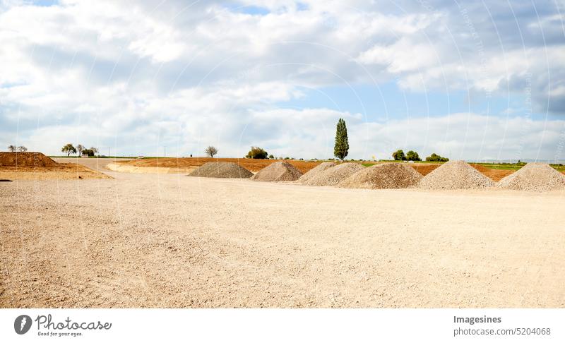 Baustelleneinfahrt. Haufen Sand und Kies für den Bau. Kalksteinmaterialien für die Bauindustrie. landwirtschaftlicher Bereich Zement Wolke Himmel Beton