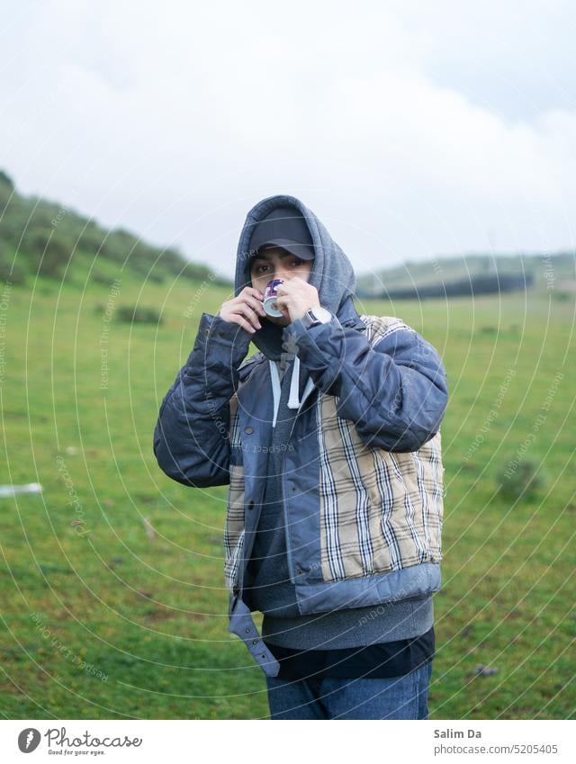 Stilvoller Mann, der seine Zeit in der Natur genießt grün Grün Grünfläche grüner Hintergrund Kaffee Tee Getränk Getränke stylisch schicke Kleidung