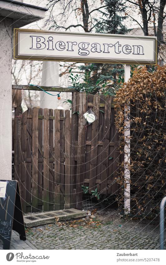 Biergarten, einladender Eingang mit Holztor und Lichterkette wartet auf die Saison verlassen Einladung feiern trist alt geschlossen Tür Holztür