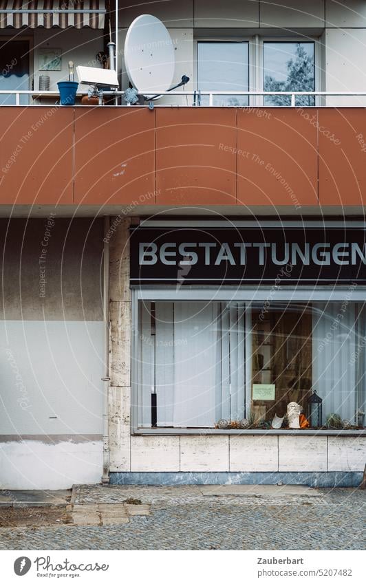 Bestattungen Schaufenster eines Bestatter, Trauer und Verlust, darüber Balkon und Satellitenschüssel als geometrisches Fassaden-Ensemble Tod Todesfall Wohnhaus