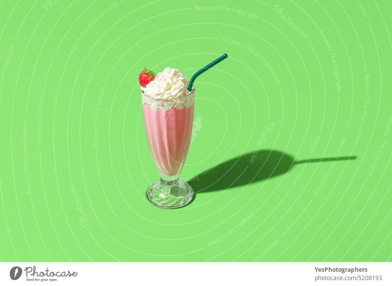 Milkshake Glas minimalistisch auf einem grünen Hintergrund. Hausgemachte Erdbeeren Milchshake oben Getränk hell Cocktail kalt Farbe Textfreiraum Sahne Küche