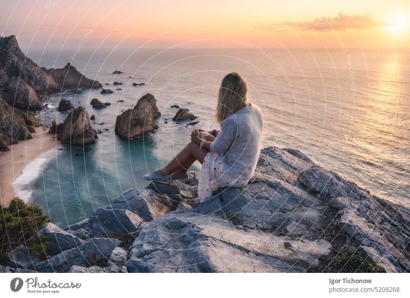 Schöne Touristinnen genießen den Sonnenuntergang am Praia da Ursa Beach. Surreale Szenerie von Sintra, Portugal. Atlantischer Ozean Küstenlinie Landschaft